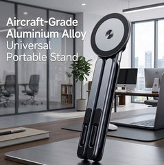 A black and silver aluminum portable stand with a circular top, shown standing on a wooden desk in a modern office environment. White text on the left reads 'Aircraft-Grade Aluminium Alloy Universal Portable Stand'.